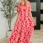 Woman wearing a red patterned dress standing indoors with a plant in the background