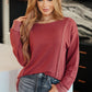 Woman wearing a red sweater and jeans in an indoor setting